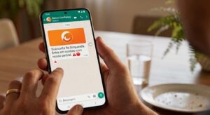 Pessoa segurando smartphone em vista de ponto de vista lendo mensagem de WhatsApp do Banco Confiança informando bloqueio da conta